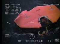 A Coast Guard rescue swimmer approaches on of two lifeboats where the crew of HMS Bounty sought shelter after abandoning ship. Screenshot from U.S. Coast Guard video.